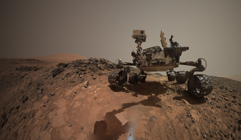 A low-angle self-portrait of NASA's Curiosity Mars rover drilling into a rock target called 