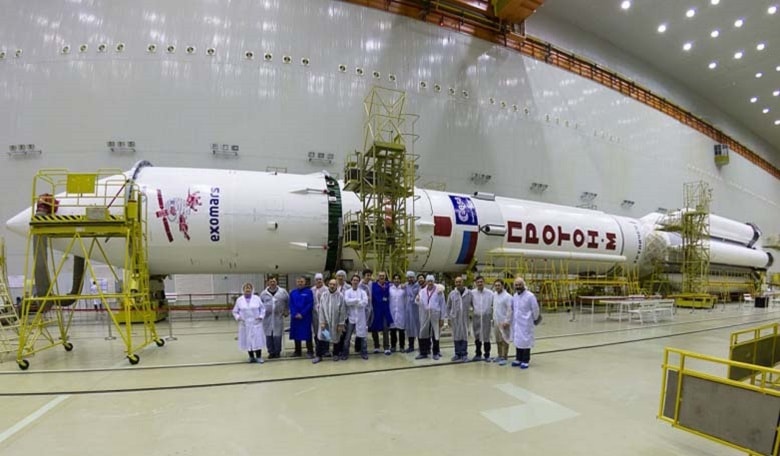 Some of the team at Baikonur who are preparing the ExoMars 2016 spacecraft for launch, pictured in front of the Proton rocket.